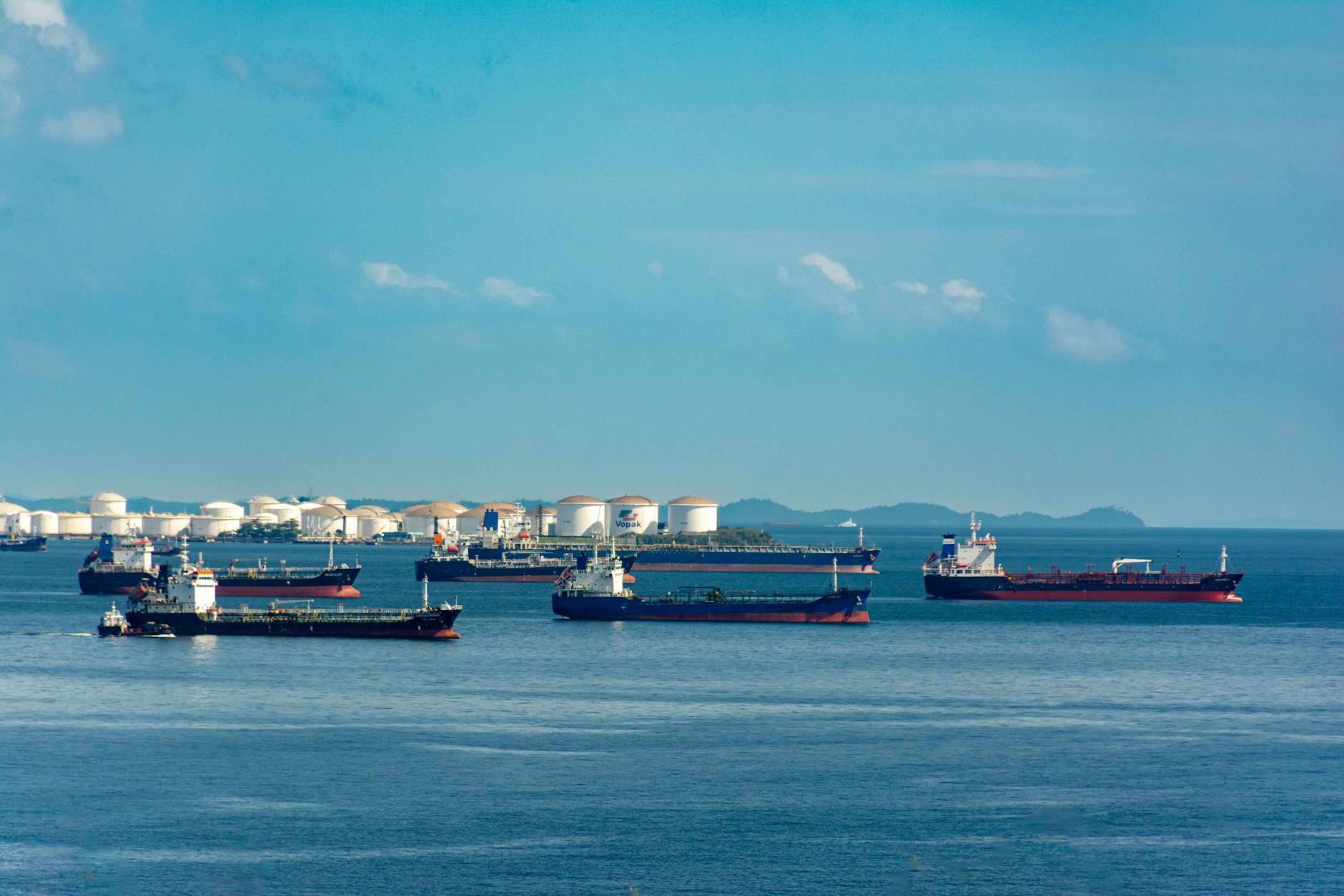 cargo ships anchored at coastal port under blue sky