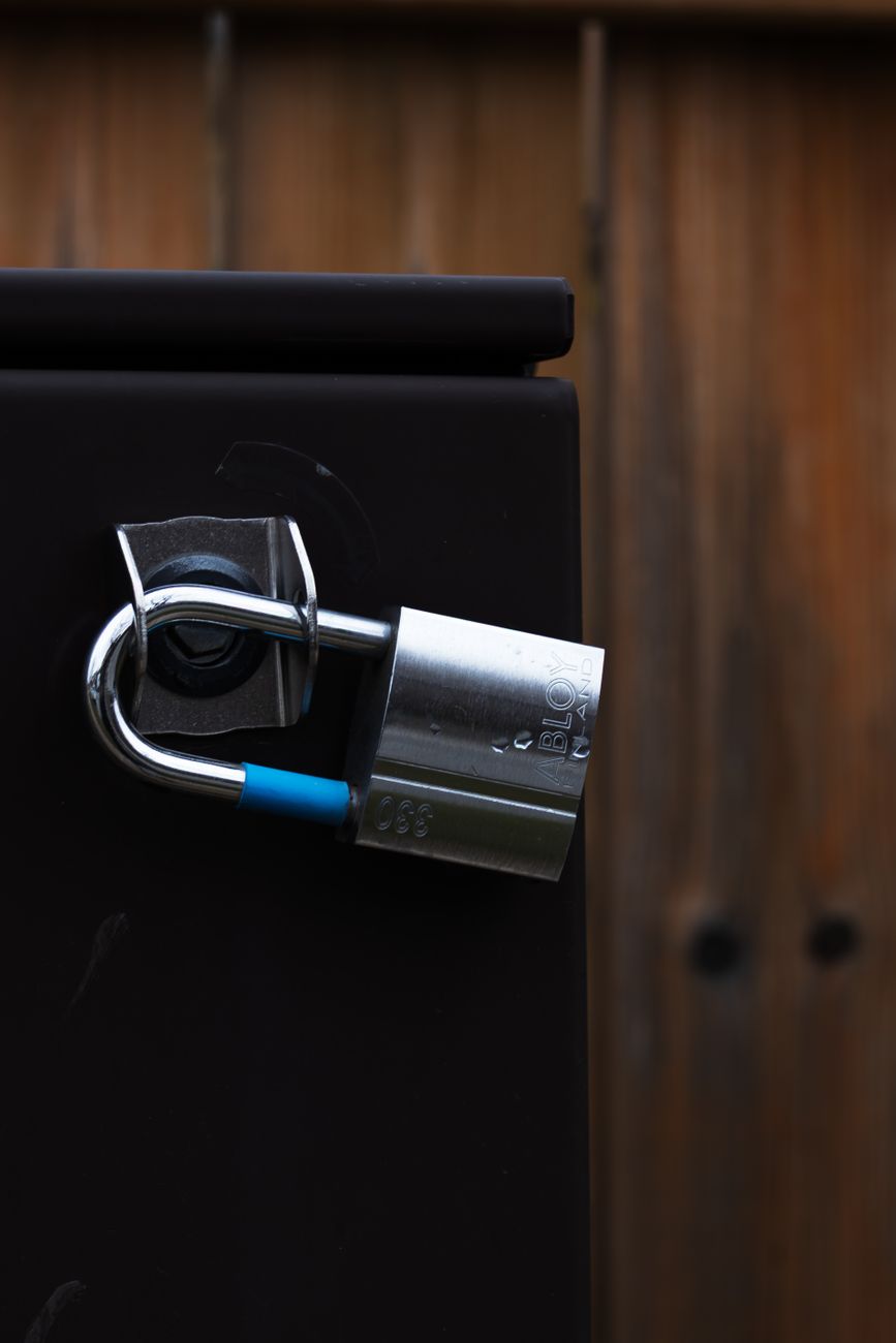 close up of secured metal padlock on wooden door